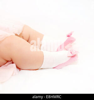 Winziges Baby Füße in rosa Schuhe der Neugeborenen Prinzessin auf einem weißen Bett Stockfoto