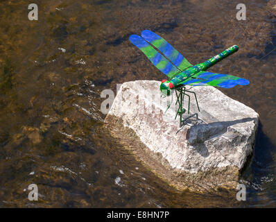 Künstliche Libelle auf einen Stein am Fluss Stockfoto