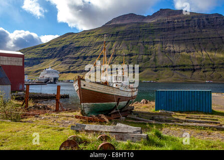 Altes Fischerboot in Island durch modernes transatlantischen in den Rücken Stockfoto