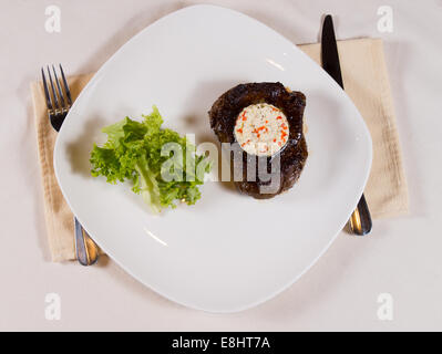 Übersicht der Steaks garniert mit Kräutern Butter auf Teller Gedeck auf Tisch Stockfoto