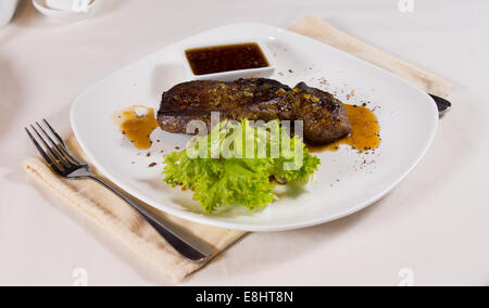 Steak auf dem Teller garniert an Gedeck im Restaurant Stockfoto