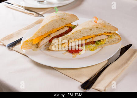 Vergoldete Sandwich serviert auf quadratischen Ciabatta Roll am Restaurant Gedeck Stockfoto