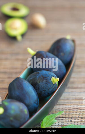 Avocado Früchte in Keramikschale auf gewebte Matte Stockfoto