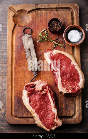 Rohes Frischfleisch Ribeye Steak würzen und Vintage Steelyard auf dunklem Hintergrund Stockfoto