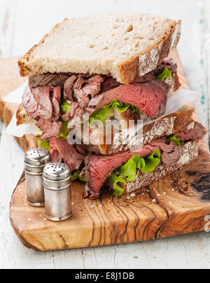 Roast Beef Sandwiches mit Salat auf Oliven Holz Schneidebrett Stockfoto