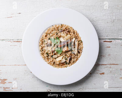 Risotto mit Waldpilzen mit Petersilie und Parmesan auf blauem Hintergrund Stockfoto