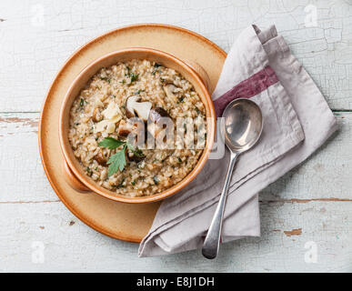 Risotto mit Waldpilzen mit Petersilie und Parmesan auf blauem Hintergrund Stockfoto