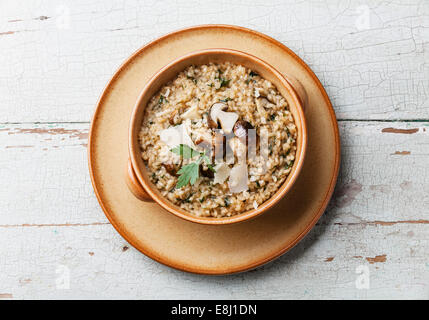 Risotto mit Waldpilzen mit Petersilie und Parmesan auf blauem Hintergrund Stockfoto