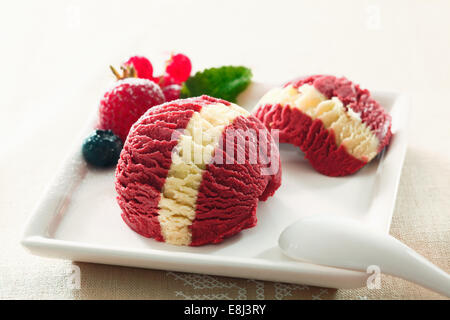 Doppelte Schaufel dienen der fruchtig bunten Beeren Eiscreme mit einem markanten Vanille Streifen auf der Mitte Stockfoto