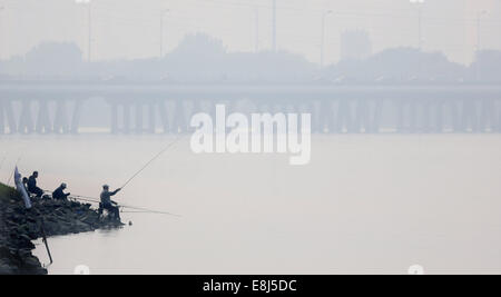 Shenyang, China Liaoning Provinz. 9. Oktober 2014. Menschen Sie Fisch von einem Smog gehüllten Fluss in Shenyang, Hauptstadt des nordöstlichen Chinas Liaoning Provinz, 9. Oktober 2014. Bildnachweis: Yao Jianfeng/Xinhua/Alamy Live-Nachrichten Stockfoto