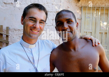 Französische Priester Etienne Kern mit ein Gemeindemitglied in Alagados favela Stockfoto