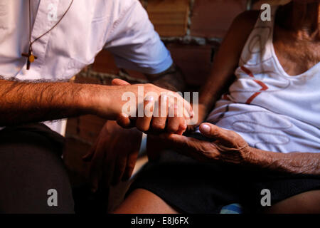 Französische Priester Etienne Kern besuchen ein Gemeindemitglied in Alagados favela Stockfoto