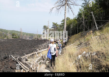 Wanderer zu Fuß durch Lava und tot verbrannte Bäume auf der Nordseite des Ätna Sizilien Italien Stockfoto