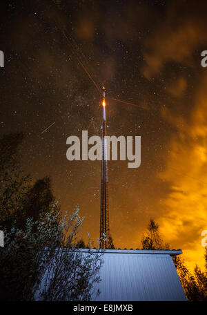 Ein Link-Fernmeldeturm mit einem blinkenden Licht. Nachthimmel mit Sternen im Hintergrund. Stockfoto