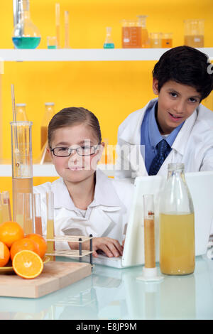 Kinder, die Durchführung eines Experiments auf Orangen Stockfoto