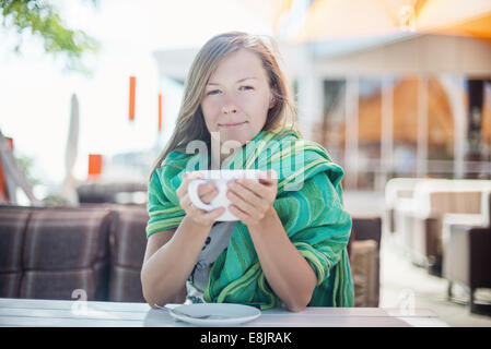 Glückliche Frau hält eine Tasse Kaffee Stockfoto