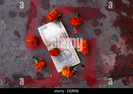 Hakenkreuz, Blumen und Geld Angebote auf ein heiliger Fluss ghat Stockfoto