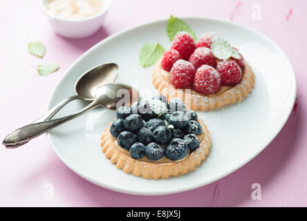 Törtchen mit frischen Himbeeren und Heidelbeeren Stockfoto