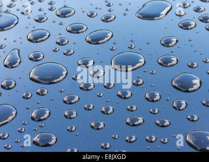 Wassertropfen auf dem Dach eines Autos nach einem Niederschlag. Stockfoto