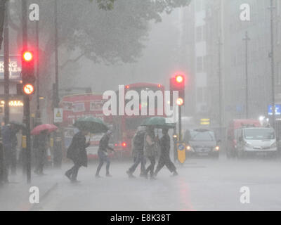 London, UK. 9. Oktober 2014. Fußgänger laufen für Cover mit Regenschirmen während starkem Regen Regenfälle in der Hauptstadt. Bildnachweis: Amer Ghazzal/Alamy Live-Nachrichten Stockfoto