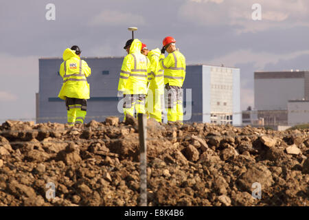 Hinkley Punkt Somerset, UK. 9. Oktober 2014. Bauarbeiten am neuen EDF Energy Hinkley Point "C" Nuclear Power Station Schritte einen Gang höher, nachdem die Europäische Union die £ 24,5 Milliarden-Projekt genehmigt.  Die aktuellen Hinkley Point 'B' und Decommisioned 'A' ist im Hintergrund eine Vermessung-Team arbeitet auf der 'C'-Website ersichtlich. Stockfoto