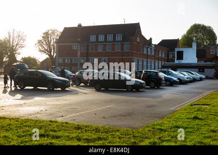 Schule-Parkplatz während der Vorlesungszeit / Autos parken am Morgen an einer primären und sekundären Schule absetzen. VEREINIGTES KÖNIGREICH. Stockfoto