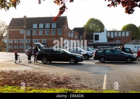 Schule-Parkplatz während der Vorlesungszeit / Autos parken am Morgen an einer primären und sekundären Schule absetzen. VEREINIGTES KÖNIGREICH. Stockfoto