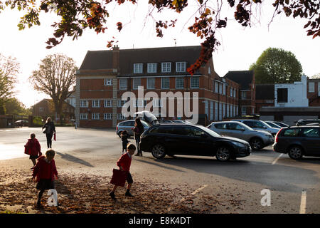 Schule-Parkplatz während der Vorlesungszeit / Autos parken am Morgen an einer primären und sekundären Schule absetzen. VEREINIGTES KÖNIGREICH. Stockfoto