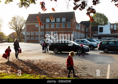 Schule-Parkplatz während der Vorlesungszeit / Autos parken am Morgen an einer primären und sekundären Schule absetzen. VEREINIGTES KÖNIGREICH. Stockfoto