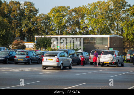 Schule-Parkplatz während der Vorlesungszeit / Autos parken am Morgen an einer primären und sekundären Schule absetzen. VEREINIGTES KÖNIGREICH. Stockfoto