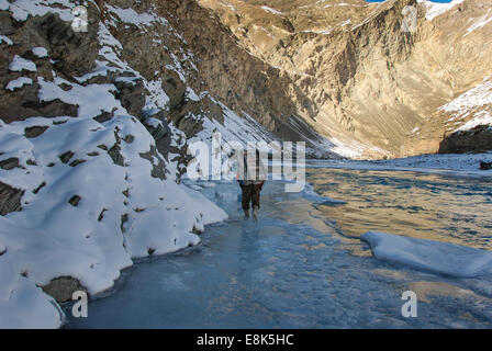 Träger mit Trekker Gepäck auf Zanskar Fluss während Chadar Trek hilft Stockfoto