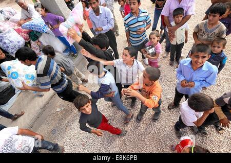 Suruc, Türkei. 9. Oktober 2014. Hunderte von Flüchtlingen, die nur eine Zeltstadt in Suruc, Türkei ankamen, erhalten Decke und Kleidung von einer Verteiler-Lkw. Die waren kommen von Hilfsorganisationen und NGOs arbeiten mit der türkischen Regierung. Schweren Kämpfen an der Grenze zwischen der Türkei und Syrien sieht mehr Flüchtlinge gegenüber Syrien in die Türkei zu überfluten. Sie sind Settleing in unfertigen Zeltstädte. Die kurdischen syrische Flüchtlinge aus Kobani haben die islamischen Staat Kämpfer flohen und Leben in Felder neben Stromnetze und auf offener Straße. Bildnachweis: ZUMA Press, Inc./Alamy Live-Nachrichten Stockfoto