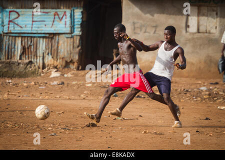 Männer spielen Fußball, Kroo Bay, Freetown, Sierra Leone. Foto © Nil Sprague Stockfoto