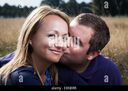 Mann küsst Freundin auf Wange Stockfoto
