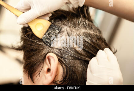 Kaukasische Mädchen bei Friseur-Service setzen Farbe mit Händen auf das nasse Haar gedreht wieder hautnah Stockfoto