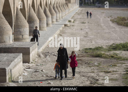 Isfahan, der Iran. 9. Oktober 2014. 9. Oktober 2014 - Isfahan, Iran - eine iranische Frau und ihren Kindern Fuß auf dem ausgetrockneten Zayanderood Fluss in der Stadt Isfahan 450 km (281 Meilen) südlich von Teheran. Morteza Nikoubazl/ZUMAPRESS © Morteza Nikoubazl/ZUMA Draht/Alamy Live-Nachrichten Stockfoto