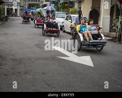 George Town, Penang, Malaysia. 7. Oktober 2014. Chinesische Touristen fahren eine Rikscha (powered Rikscha) in George Town (auch Georgetown), der Hauptstadt des Bundesstaates Penang in Malaysia. Benannt nach der britischen König George III, George Town befindet sich an der Nord-Ost-Ecke der Insel Penang. Die innere Stadt hat eine Bevölkerung von 720.202 und die metropolitan Area bekannt als George Town Ballungsraum aus Penang Island, Seberang Prai, Kulim und Sungai Petani hat eine Gesamtbevölkerung von 2.292.394, damit die zweitgrößte Metropolregion in Malaysia. Die innere Stadt George Town ist Stockfoto