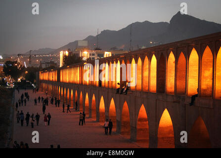 (141010)--ISFAHAN, 10. Oktober 2014 (Xinhua)--Menschen herumlaufen "Si-o-Seh Pol" Brücke in Isfahan, Iran, 9. Oktober 2014. Isfahan, die drittgrößte Stadt im Iran, ist eine historische Stadt, die bekannt für antiken Architekturen, feine Teppiche, Silber Filigran und Kunsthandwerk. (Xinhua/Ahmad Halabisaz) Stockfoto
