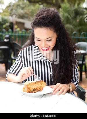 junge Frau, die ein Stück Kuchen zu genießen Stockfoto