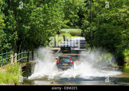 Während der Fahrt durch einen Bach. Ein Auto Spritzwasser, wenn sie durch die Furt überqueren der Straße bei Rufford, Nottinghamshire, England, Großbritannien Stockfoto