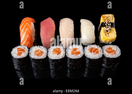 Satz von Rollen von Sushi und Sashimi auf schwarzem Hintergrund Stockfoto