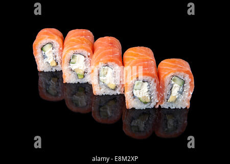 Set von Sushi Rollen verpackt in Lachs auf schwarzen Hintergrund Stockfoto