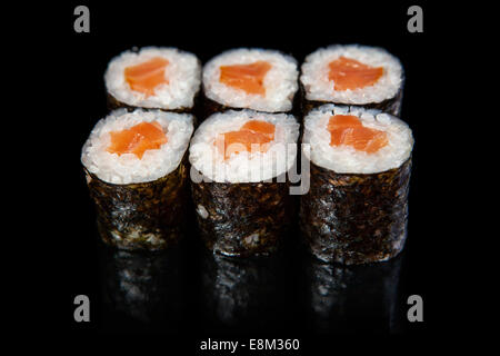 Satz von Sushi rolls mit Lachs auf schwarzen Hintergrund Stockfoto