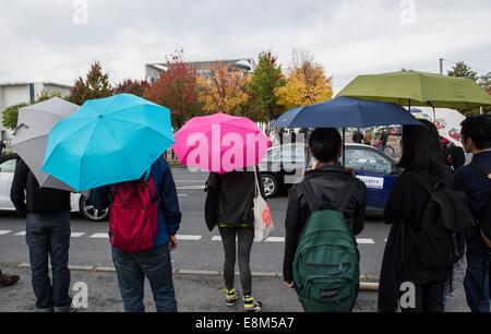 Berlin, Deutschland. 10. Oktober 2014. Menschen halten Regenschirme als Zeichen des Protests gegen den chinesischen Umgang mit der Demokratiebewegung Hongkong außerhalb der Bundeskanzlei mit chinesischen und deutschen Fahnen in Berlin, Deutschland, 10. Oktober 2014. Die dritte deutsche chinesische Regierung Konsultationen findet in Berlin heute. Bildnachweis: Dpa picture Alliance/Alamy Live News Stockfoto