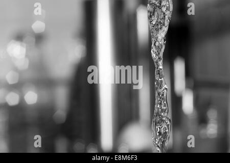 Wasser aus einem Wasserhahn in der Küche auf einen außerhalb des Fokus Hintergrund ausgeführt. Stockfoto