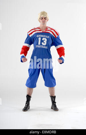 Mann in Komödie Kostüm als ein american Footballspieler mit voller Sport kit Stockfoto