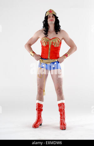 Mann in der Komödie Kostüm in einem DC Comics Wunder Frau Superhelden-Outfit mit roten Stiefeln, Hotpants, Perücke und rotes top Stockfoto