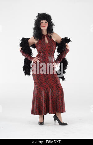 Frau in Komödie Kostüm in eine rote Schlangenhaut Kleid mit Feder Laube und schwarze Perücke Stockfoto