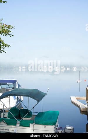 Boote sind am Pier auf Pontoosuc See in Pittsfield, Massachusetts an einem nebligen Morgen angedockt. Stockfoto