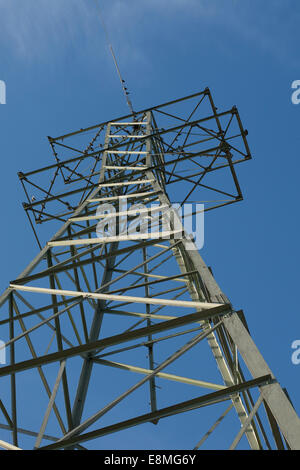 Ein Sendemast steckt voller Vögel aber hat nur eine Zeile erstreckt sich von es, wie es eine kleine Solar-Panel-Spielfeld verlässt. Stockfoto